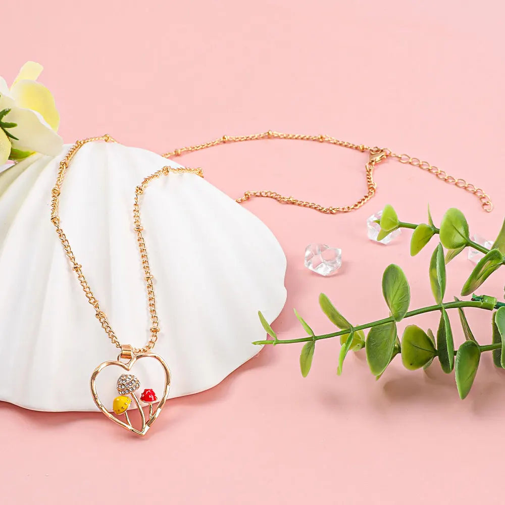 Necklace with a heart-shaped pendant featuring colorful stones on a pink background with green leaves.
