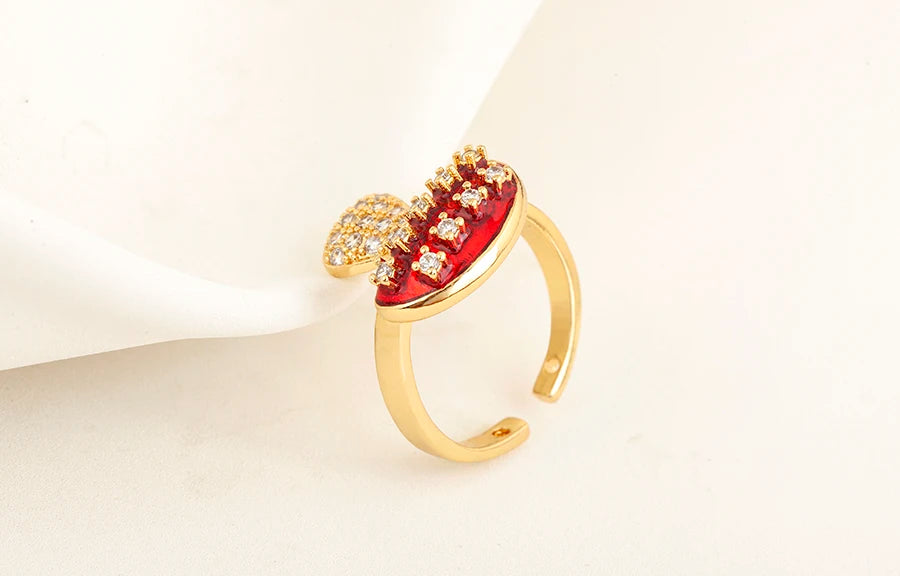 Gold ring with red gemstone on a light beige background