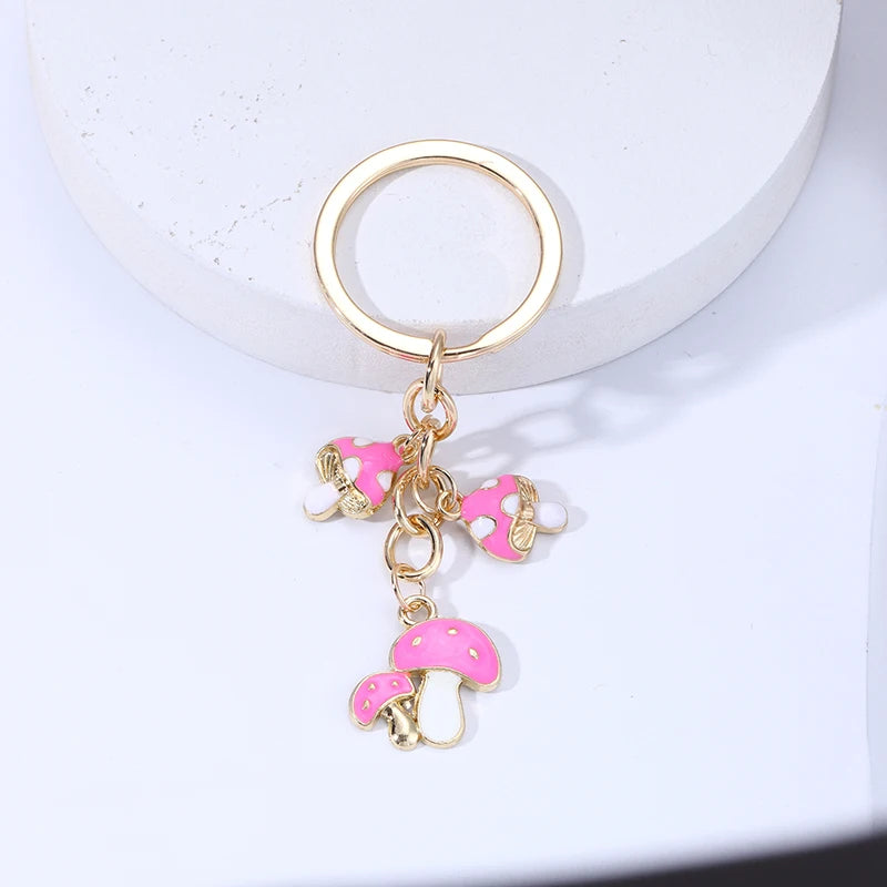 Keychain with pink mushroom and heart charms on a white background
