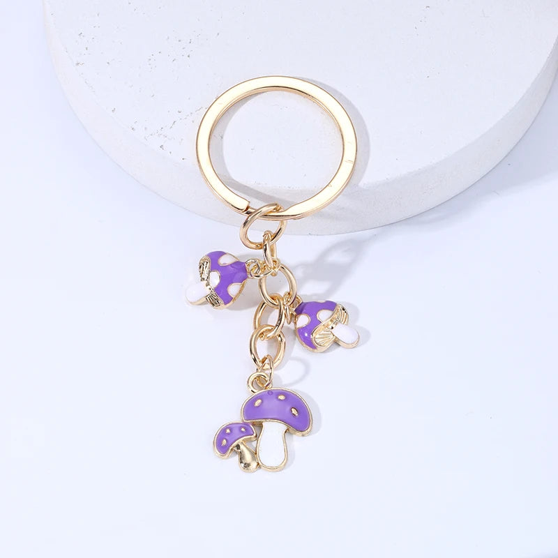 Keychain with purple mushroom charms on a light gray background
