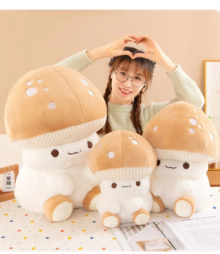 Person sitting with three plush mushroom toys on a bed.