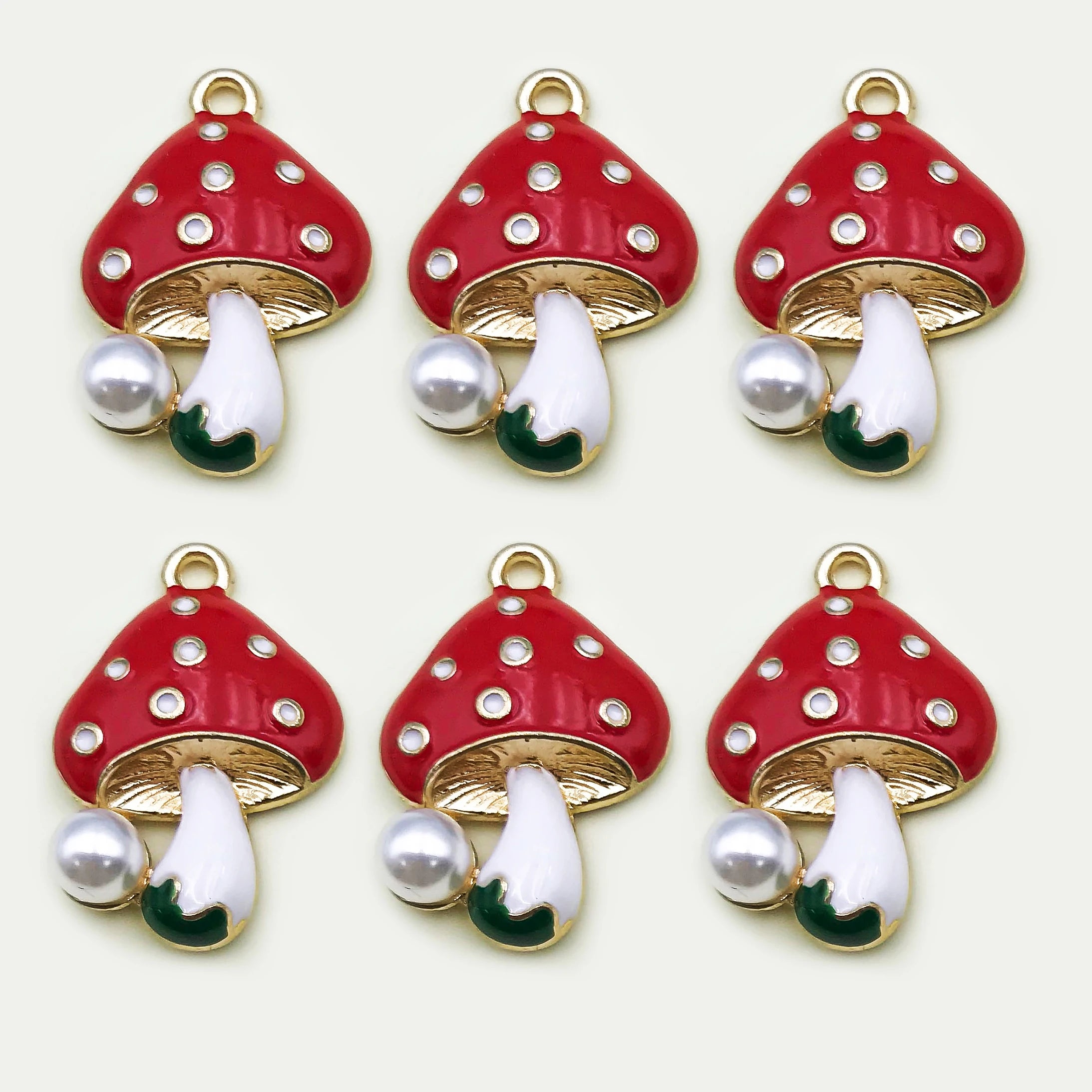 Red mushroom-shaped charms with white stems on a white background