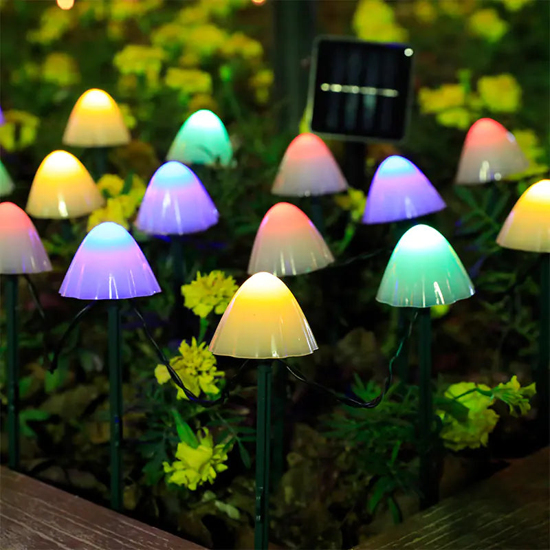 Colorful mushroom-shaped garden lights with a solar panel in the background.