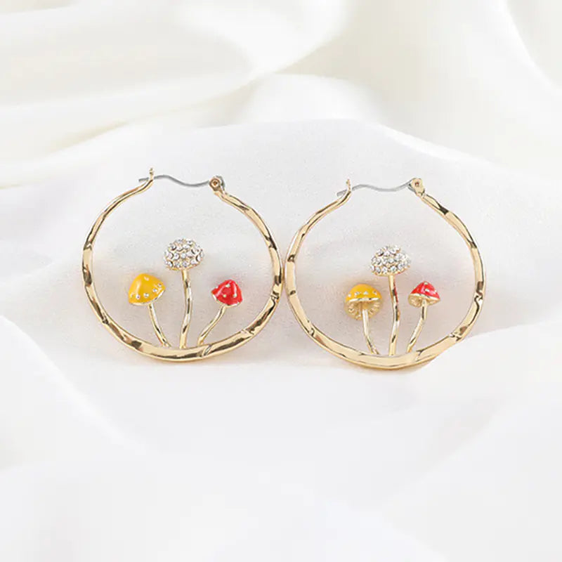 Gold hoop earrings with floral designs on a white background
