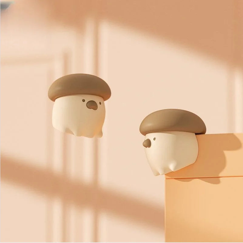 Two cartoon-like mushroom-shaped night lights on a soft pink background