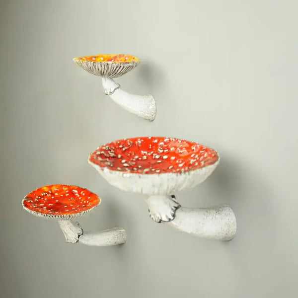 Three decorative mushroom shelves with red caps on a gray background