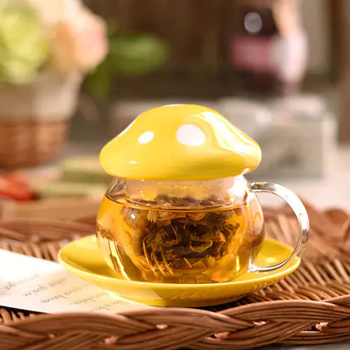 Glass teacup with yellow lid and saucer on a woven surface