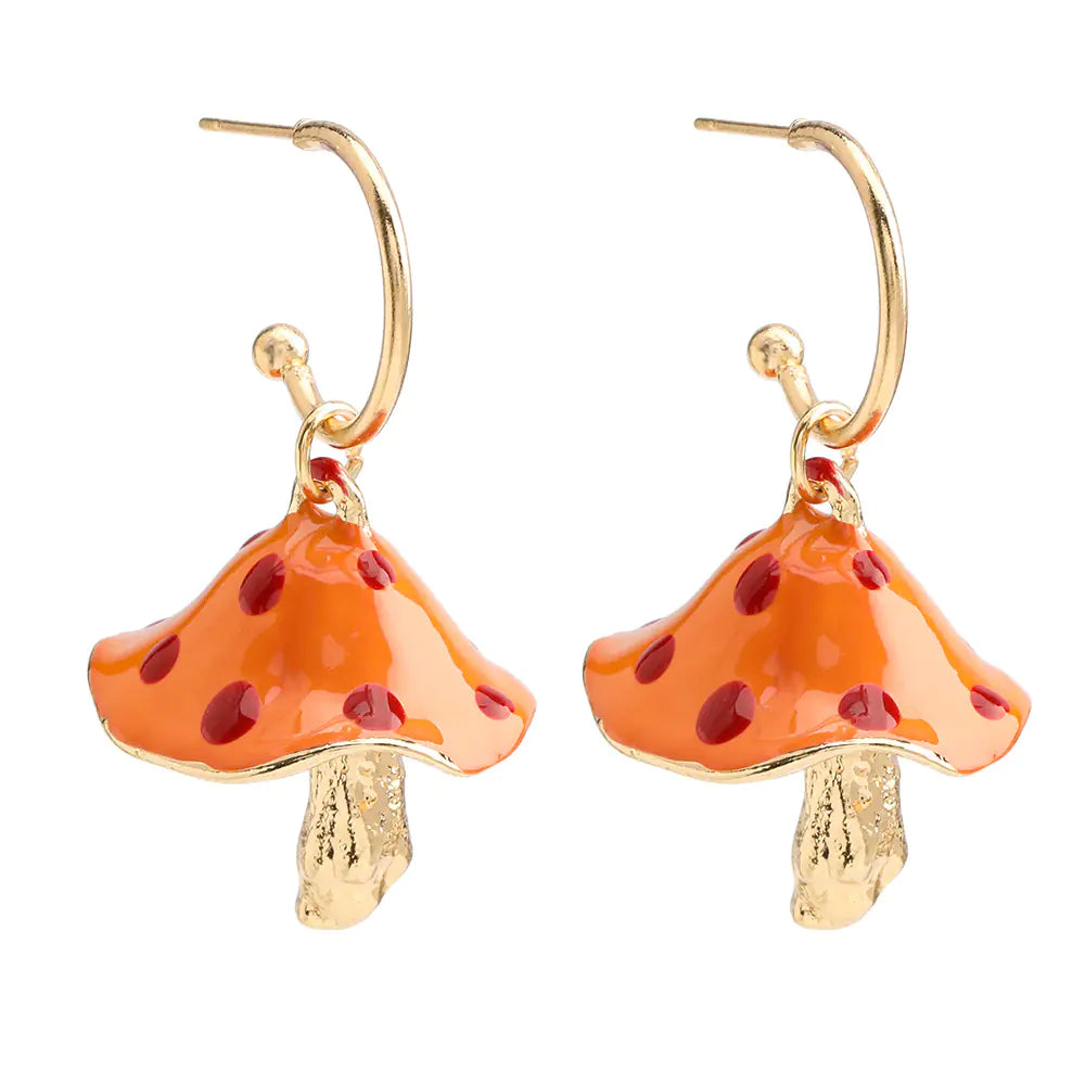 Mushroom-shaped earrings with orange caps and red spots on a white background