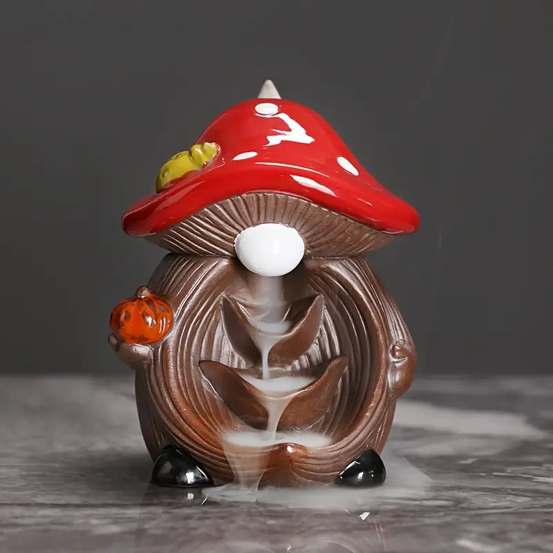 Mushroom-shaped incense burner with red cap and brown body on a dark background