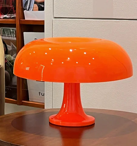 Orange table lamp on a wooden surface with a blurred background
