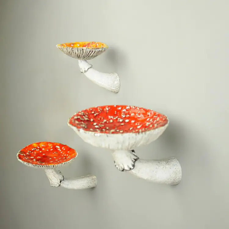 Three decorative mushroom shelves with red caps on a gray background