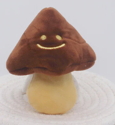 Plush mushroom toy with a smiling face on a white background