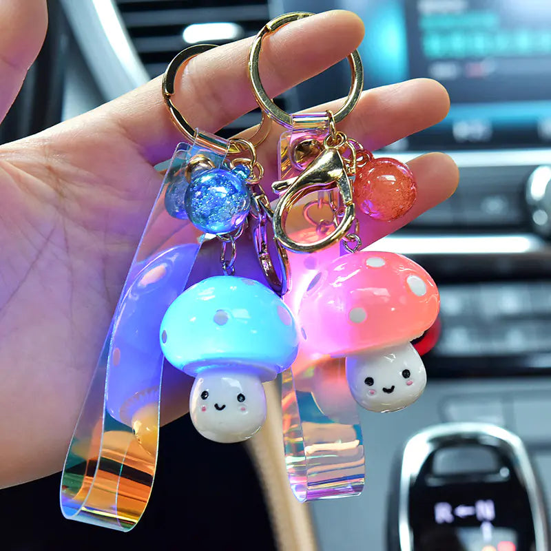 Colorful keychain with mushroom-shaped charms held by a hand in a car interior.