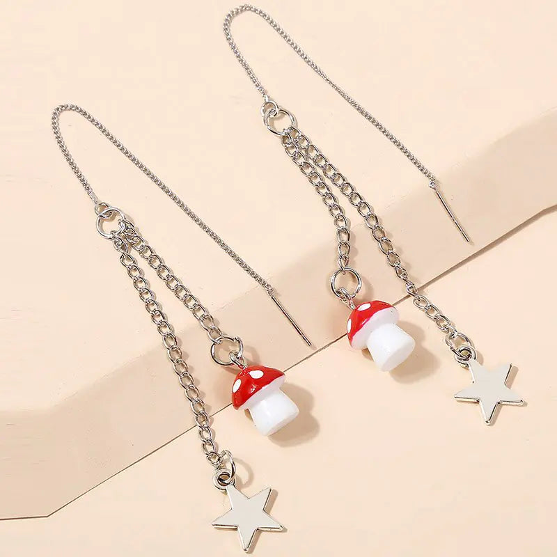 Necklace with red mushroom and star pendants on a beige background