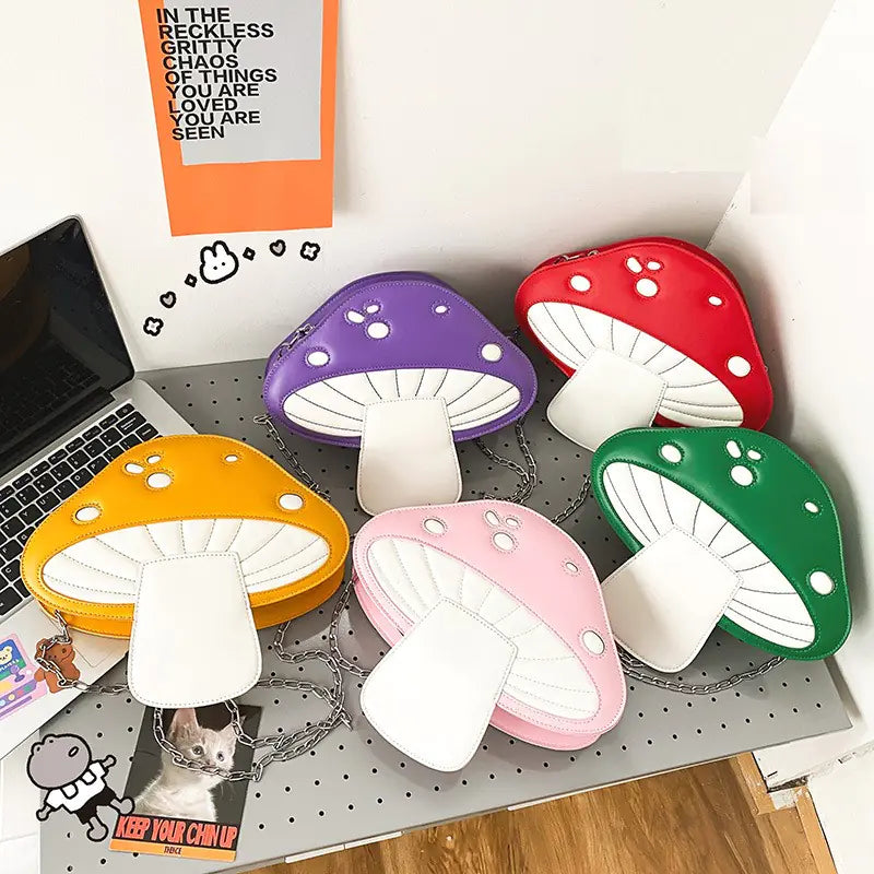 Colorful mushroom-shaped coasters on a desk with a laptop and various items.