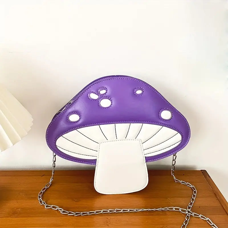 Purple and white mushroom-shaped bag with chain strap on a wooden surface.