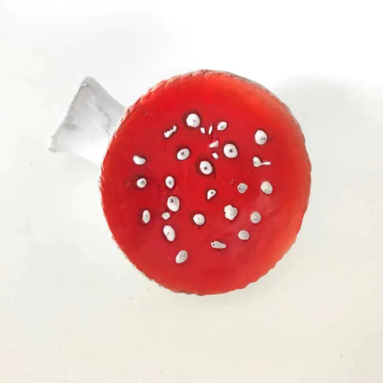 Red circular object with white specks on a white background