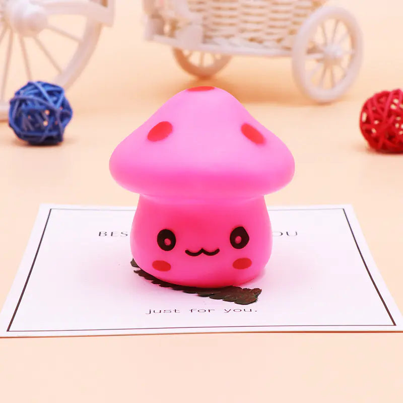 Pink mushroom-shaped toy with red spots on a light pink background