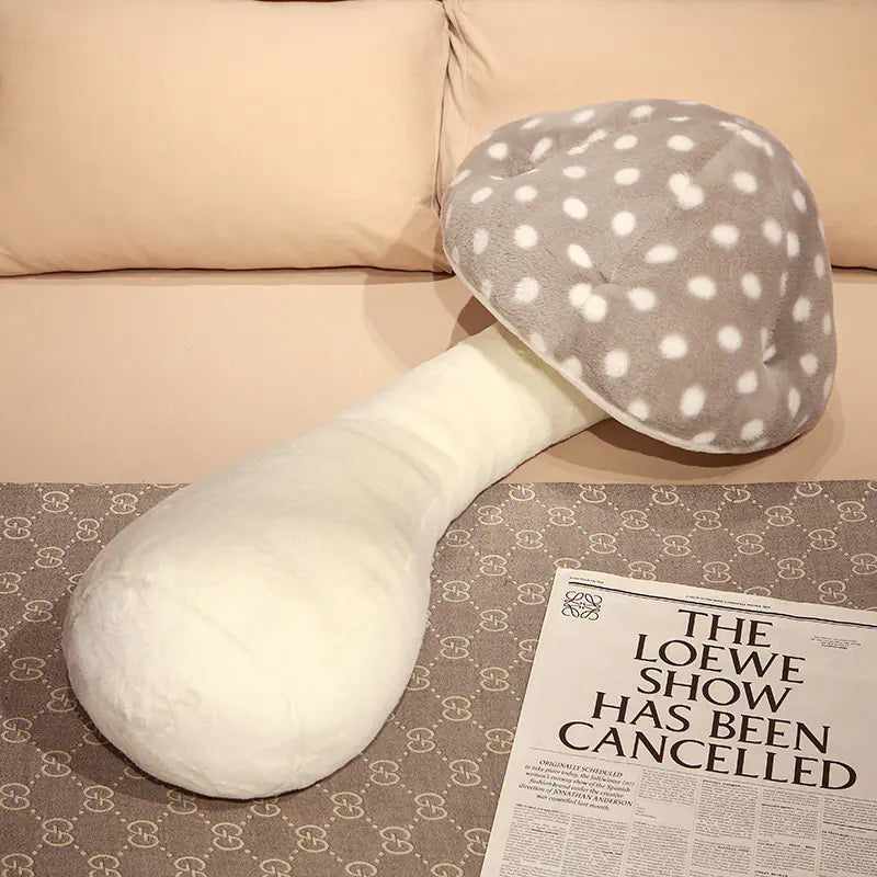 White and gray polka dot neck pillow on a surface with a newspaper.