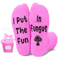 Pink socks with text and a mushroom graphic, paired with a small pink gift bag on a white background.